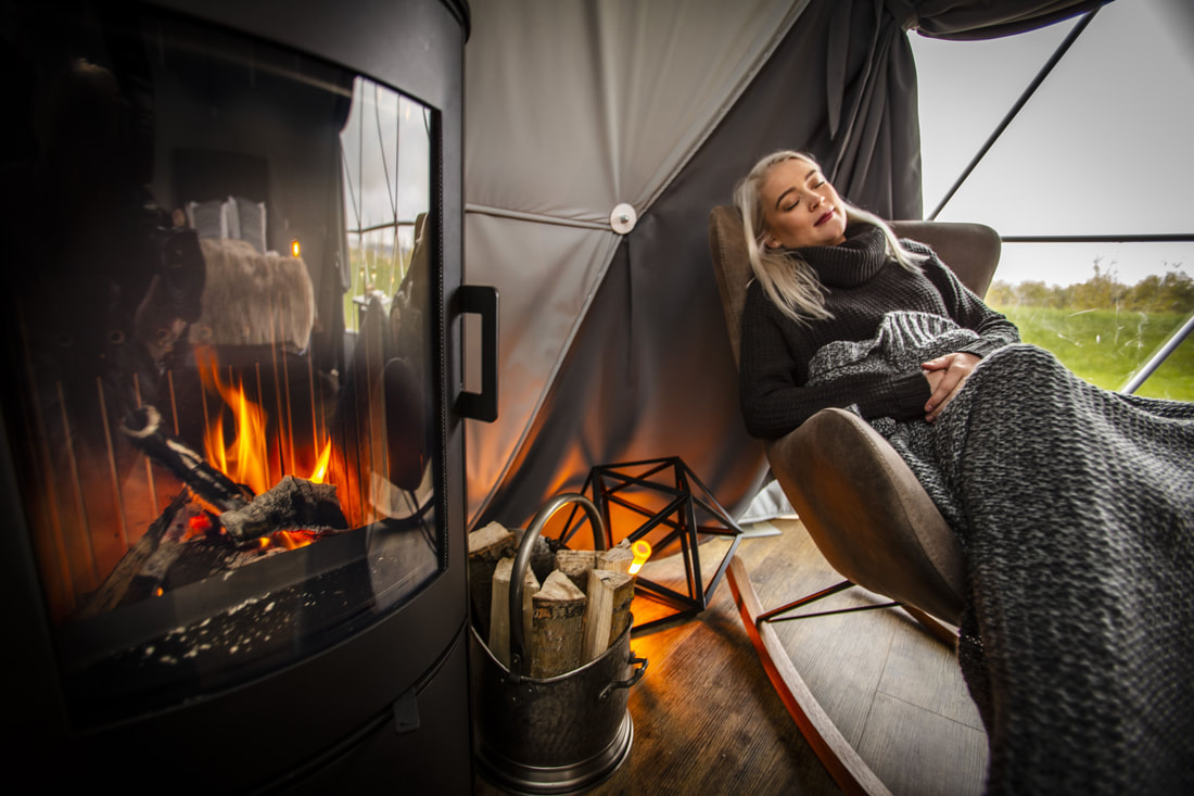 Guest reading by the fireplace in a dome